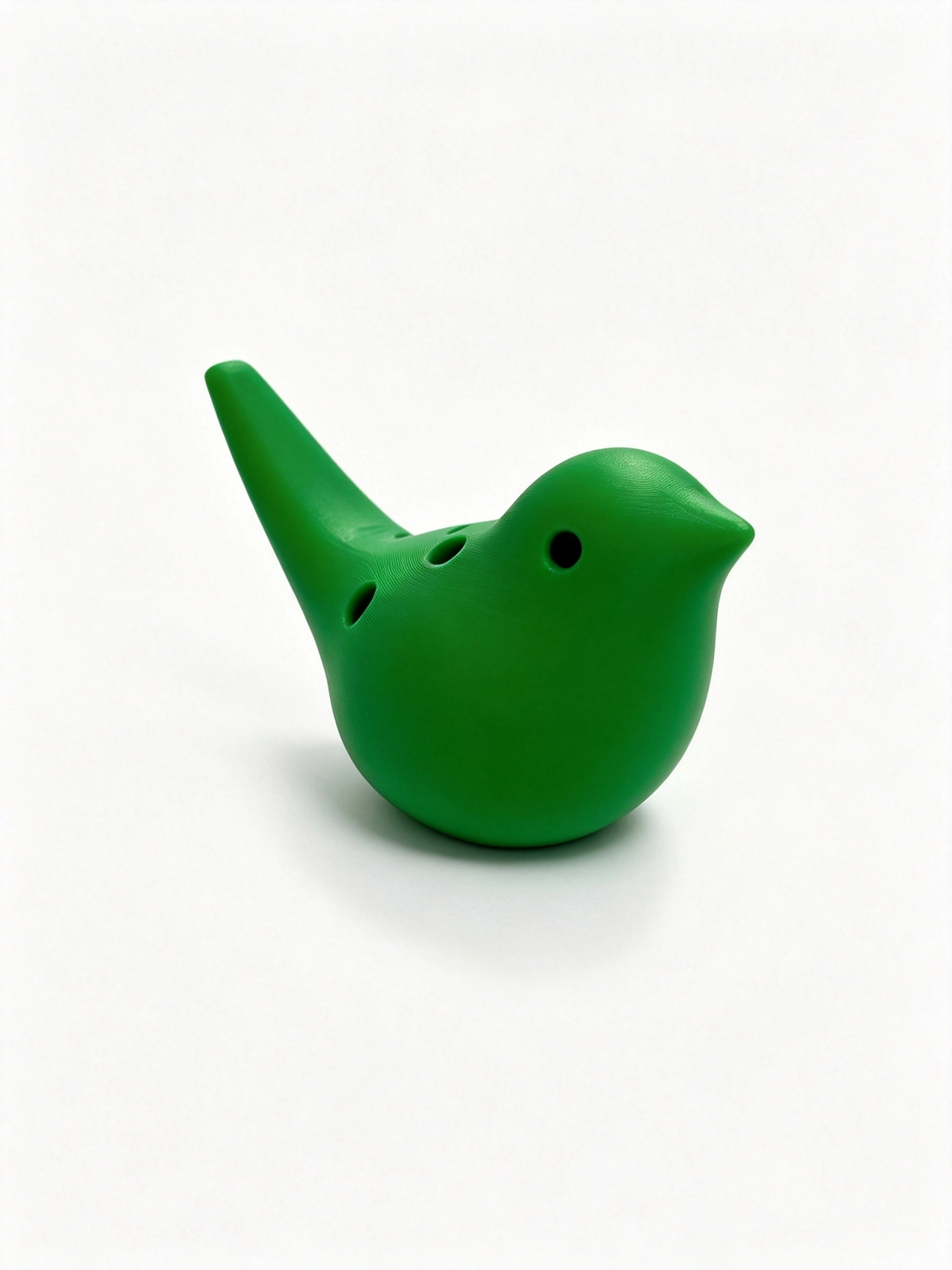 Green bird ocarina facing right, three finger holes along its shoulder and the mouthpiece angled up left