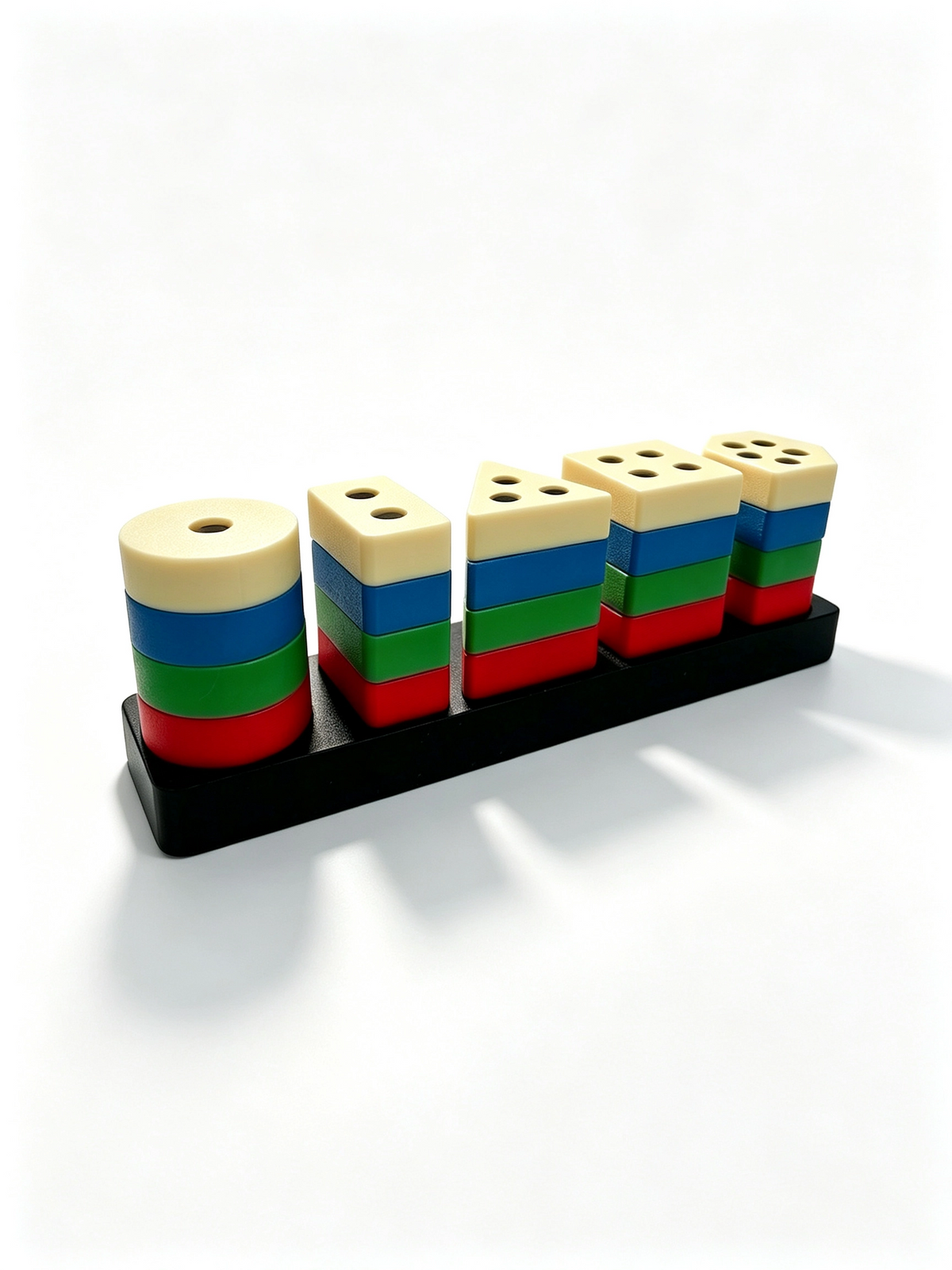 Five 3D-printed shape stacks in red, green, blue and cream on a black base, angled view